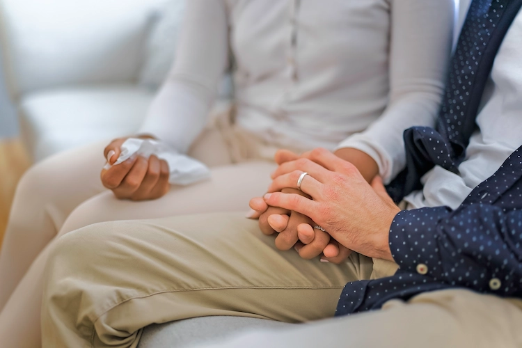 parents grieving by holding hands